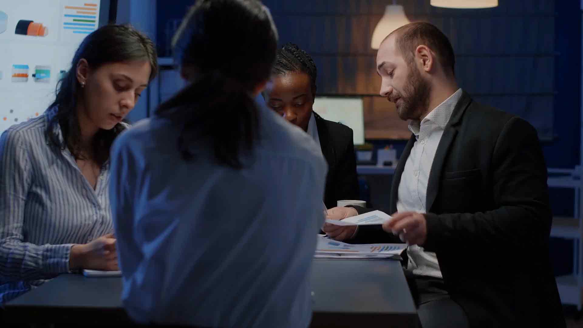 A group of professionals discussing Power BI governance strategies, with a focus on user permissions and compliance frameworks.